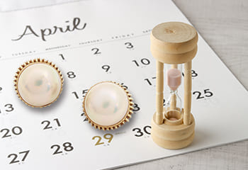 パールのイヤリングと砂時計とカレンダー