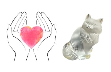 親切丁寧な鑑定士の手とラリックの猫のオブジェ