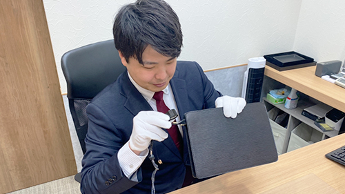ブランド品の査定をする松山