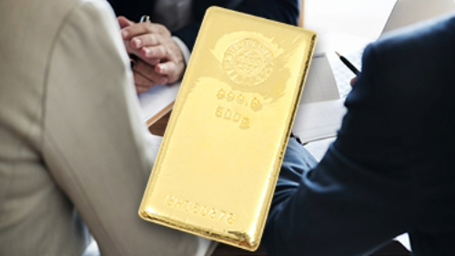 金のインゴットと鑑定士とお客様が話している様子