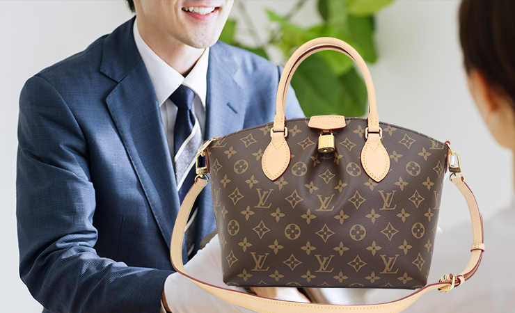 お客様がルイヴィトンのバッグを鑑定士に渡している様子